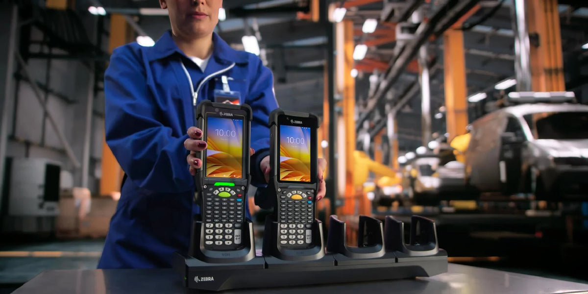 Person holding two handheld devices in a warehouse setting