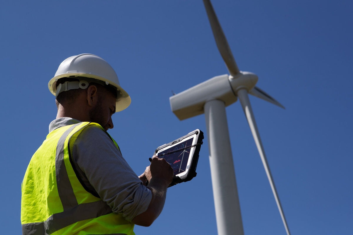 Wind farm engineer using the Panasonic TOUGHBOOK G2 mk3 (5G, EU plug) rugged tablet outdoors in direct sunlight