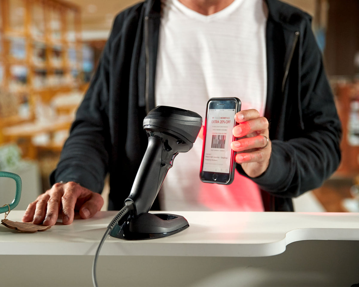 Zebra DS9908 hybrid presentation scanner, RS232 kit (DS9908-SR4R0110AZE) – scanning a phone hands-free at a retail counter